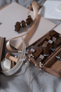 Artistic setup of wooden letter stamps, ribbons, and dried flowers on a soft background.